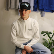 Load image into Gallery viewer, Young model wearing white 1/4 zip sweatshirt with embroidered Manifest logo, styled with casual attire.