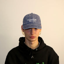 Load image into Gallery viewer, Manifest dusty denim cap with detailed embroidery, offering a vintage-inspired and stylish accessory.