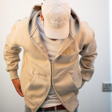 Load image into Gallery viewer, Person wearing a beige hoodie and cap against a plain background